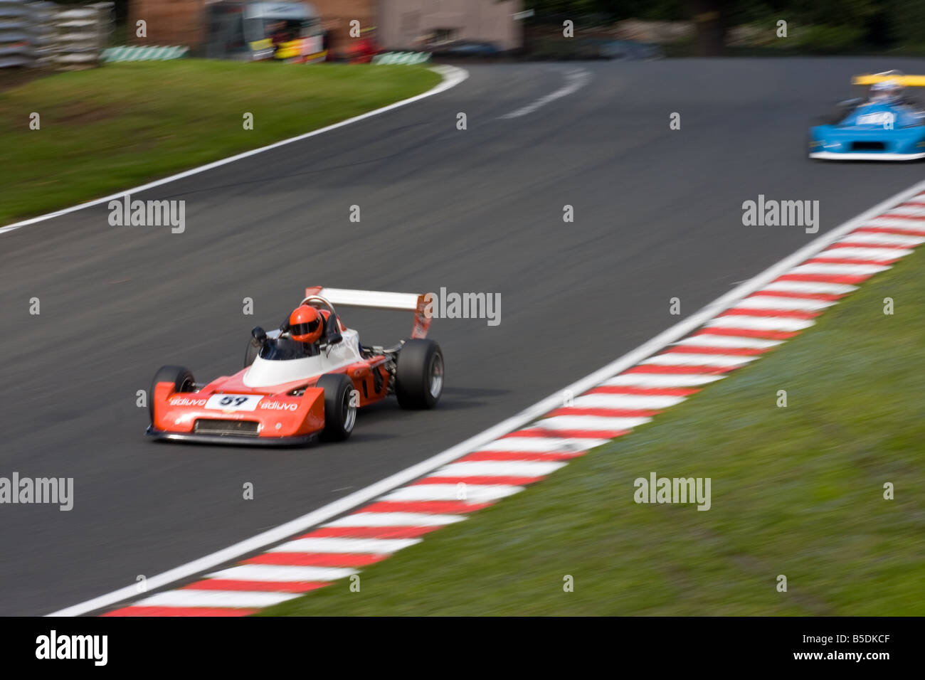 Two old classic racing cars shooting down deer leap at Oulton Park in Cheshire at the 2008 Gold Cup meet. Stock Photo