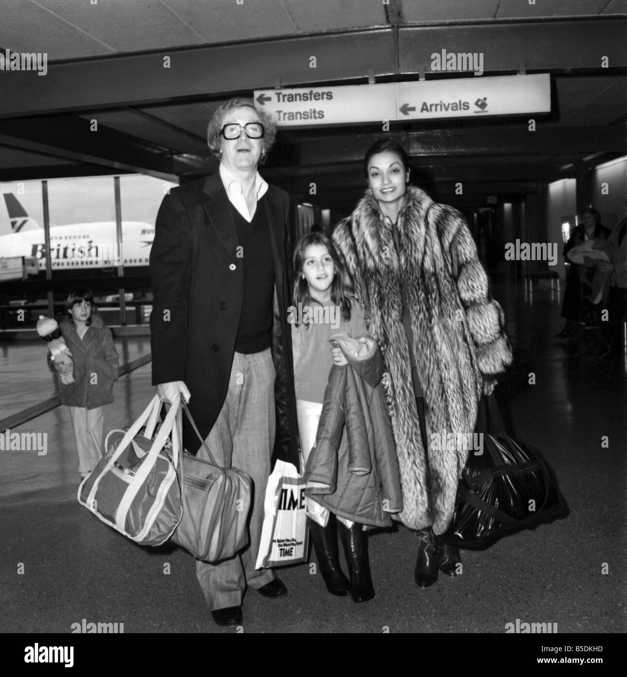 Entertainment: Film Actor: Michael Caine and wife Shakira and daughter Natasha (7) leaving Heathrow Airport for Los Angeles. They have been here for Christmas and are returning home to Hollywood and for Natasha to return to school. December 1980 80-07247 Stock Photo