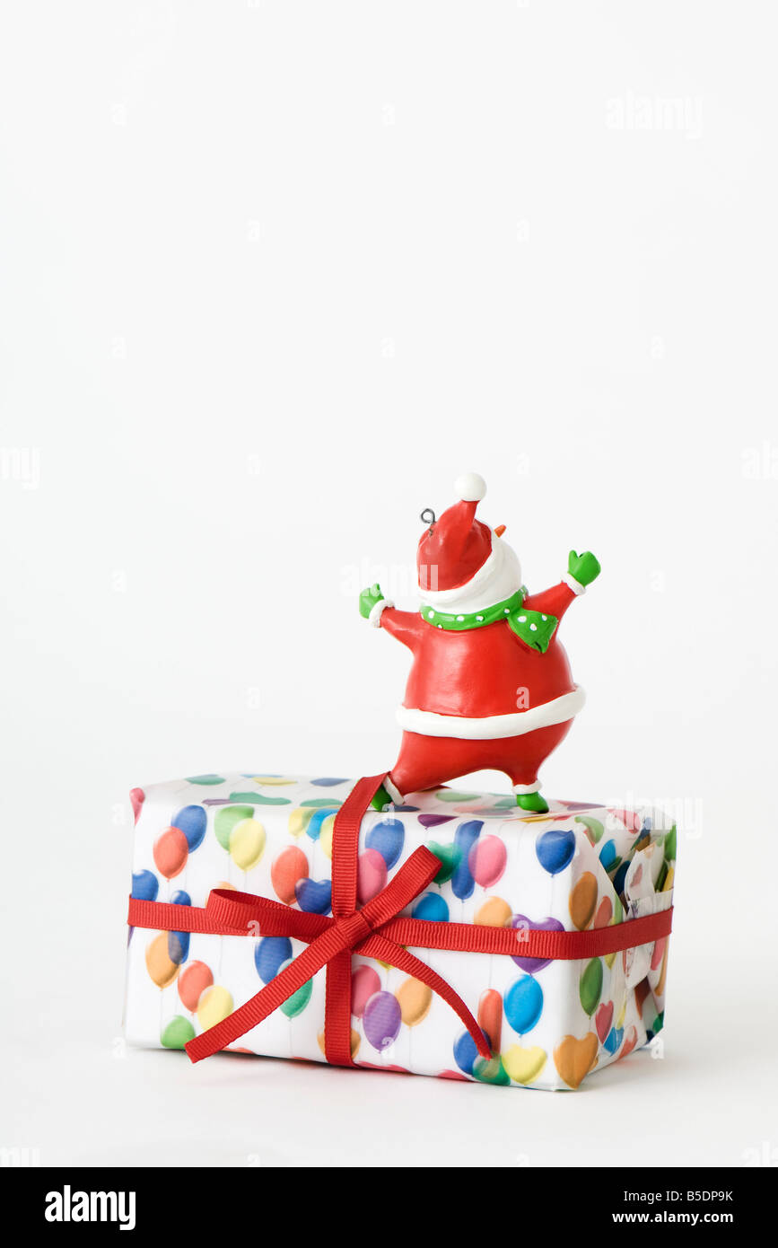Santa Claus figurine standing on top of Christmas present, rear view Stock Photo