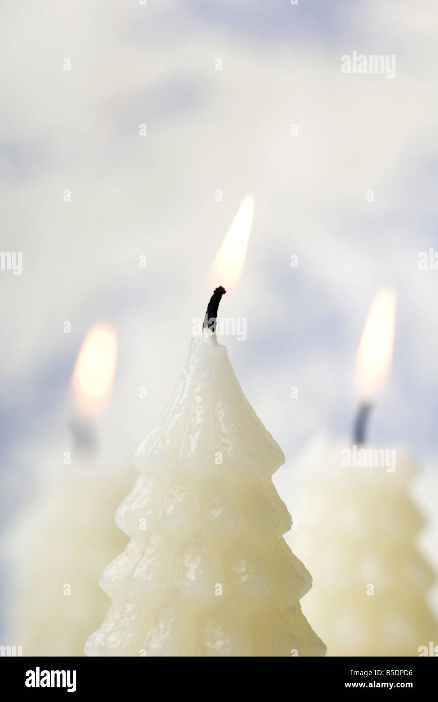 White Christmas tree shaped candles burning Stock Photo