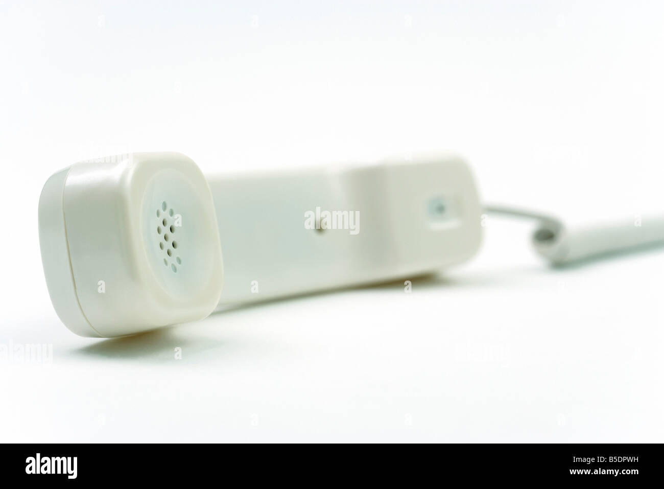 Landline phone receiver off the hook, resting on side Stock Photo