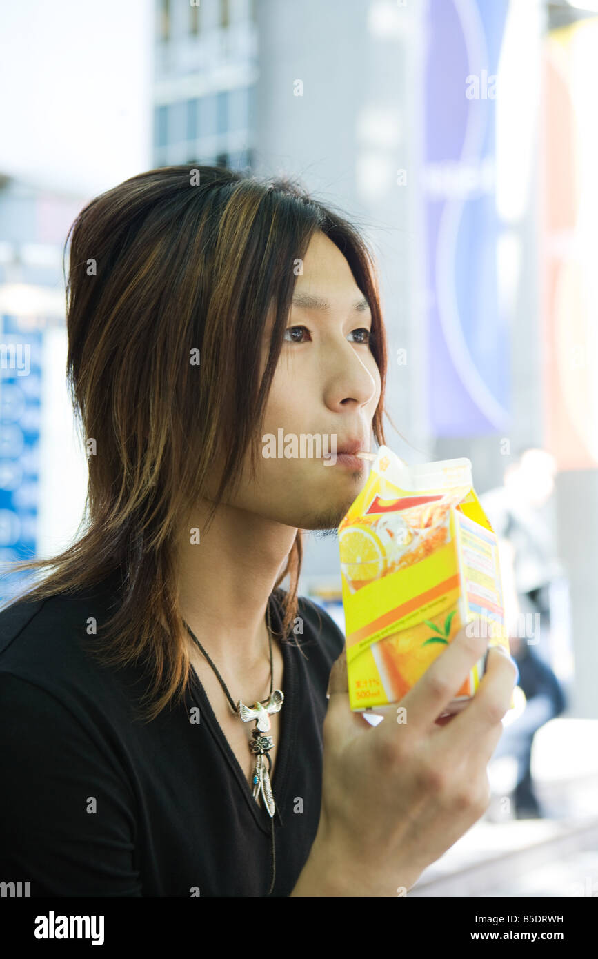 Young Japanese man drinking from juice carton Stock Photo Alamy