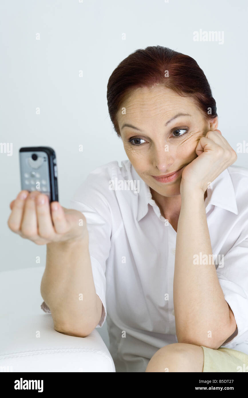 Woman using cell phone to photograph herself Stock Photo