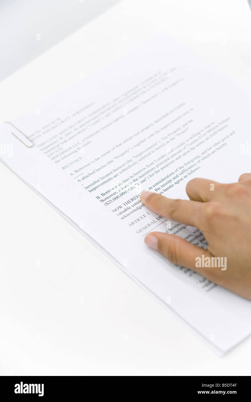Hand pointing at word on document, cropped view Stock Photo