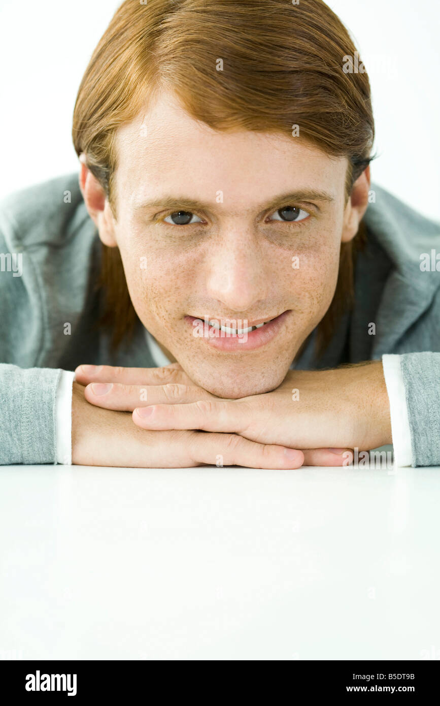 Redhaired man resting chin on hands, smiling, portrait Stock Photo Alamy