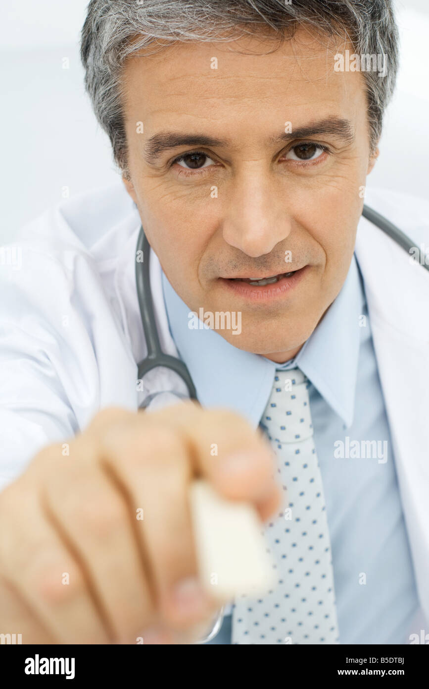 Doctor holding tongue depressor toward camera, personal perspective Stock Photo Alamy
