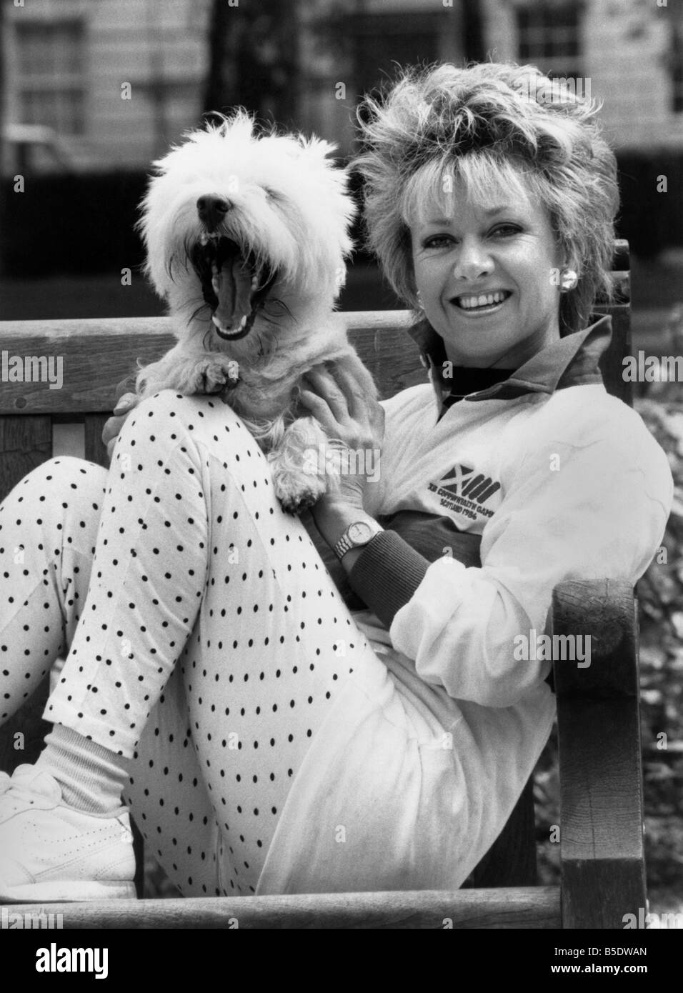 Elaine Paige: Singing star Elaine Page tunes up for the Commonwealth Games with a little help from her terrier Tugger. Elaine sportingly donned a track suit top yesterday at a sporting booster in London before the games being in Edinburgh in July. Tugger went along to chew things over. Big Yawn.Elaine Page and Tugger. June 1986 P000682 Stock Photo