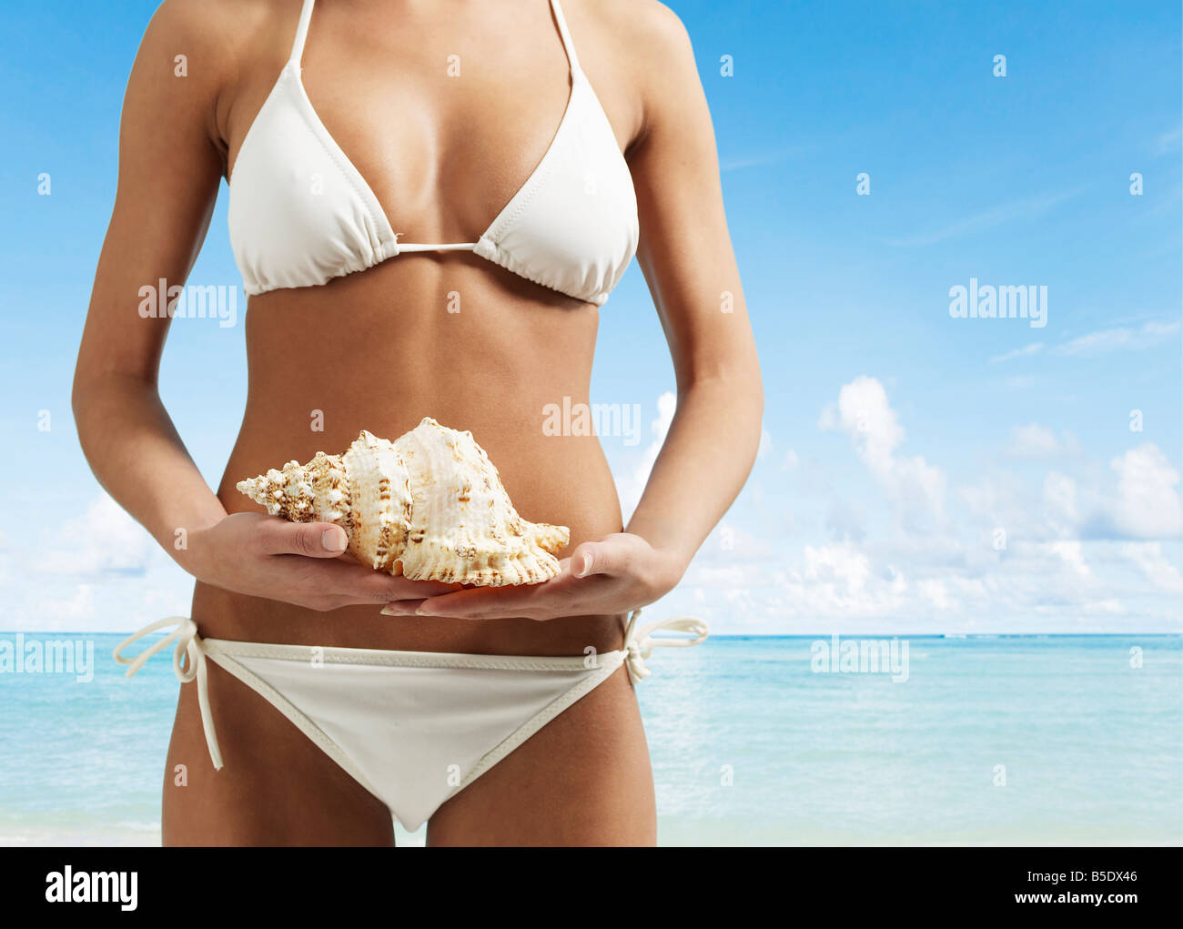 Midsection of Woman with Seashell Stock Photo