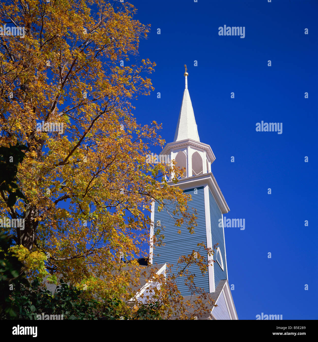 Trees in fall colours and wooden church spire at Wiscasset Maine New