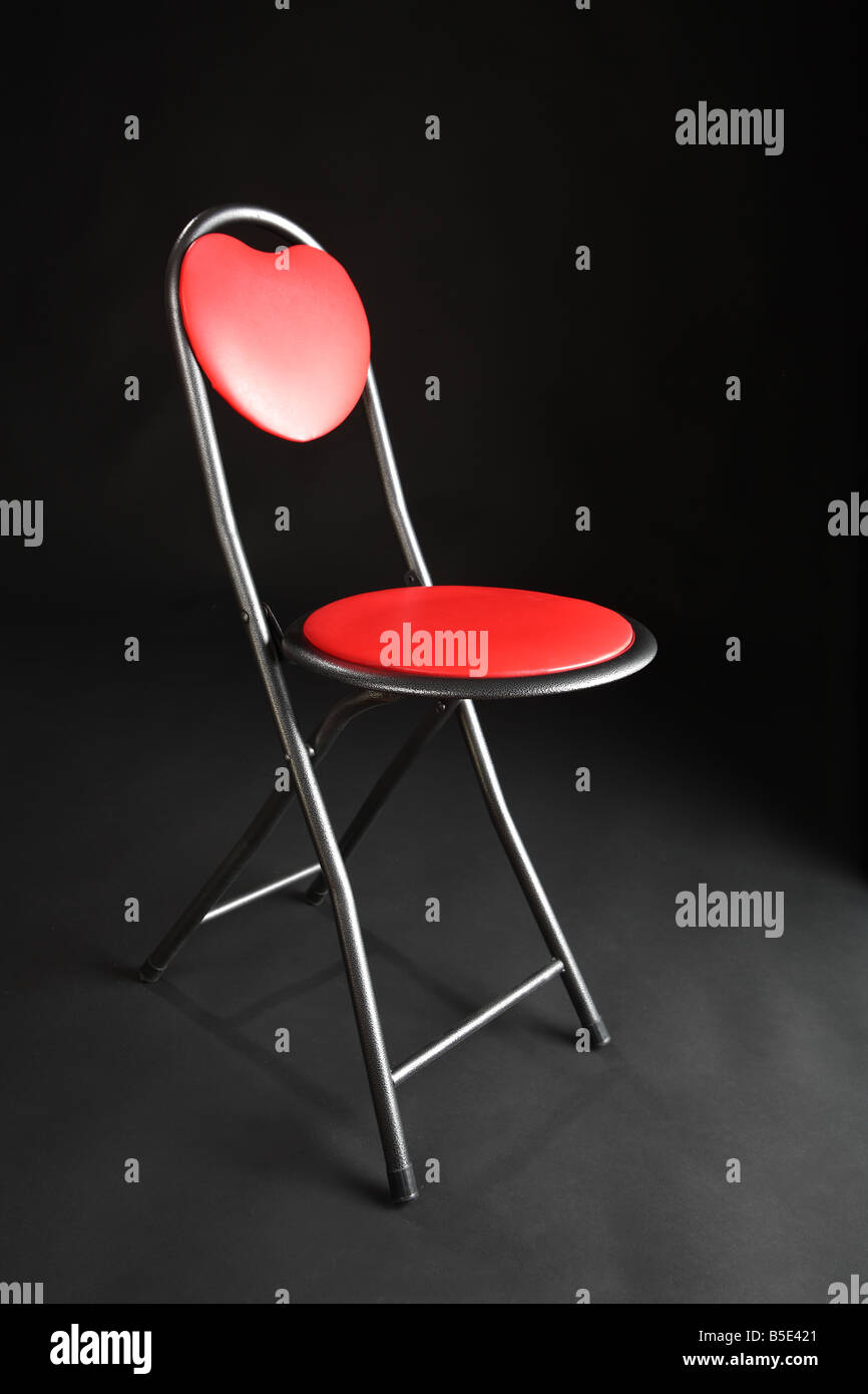 A red chair on a black studio background Stock Photo - Alamy