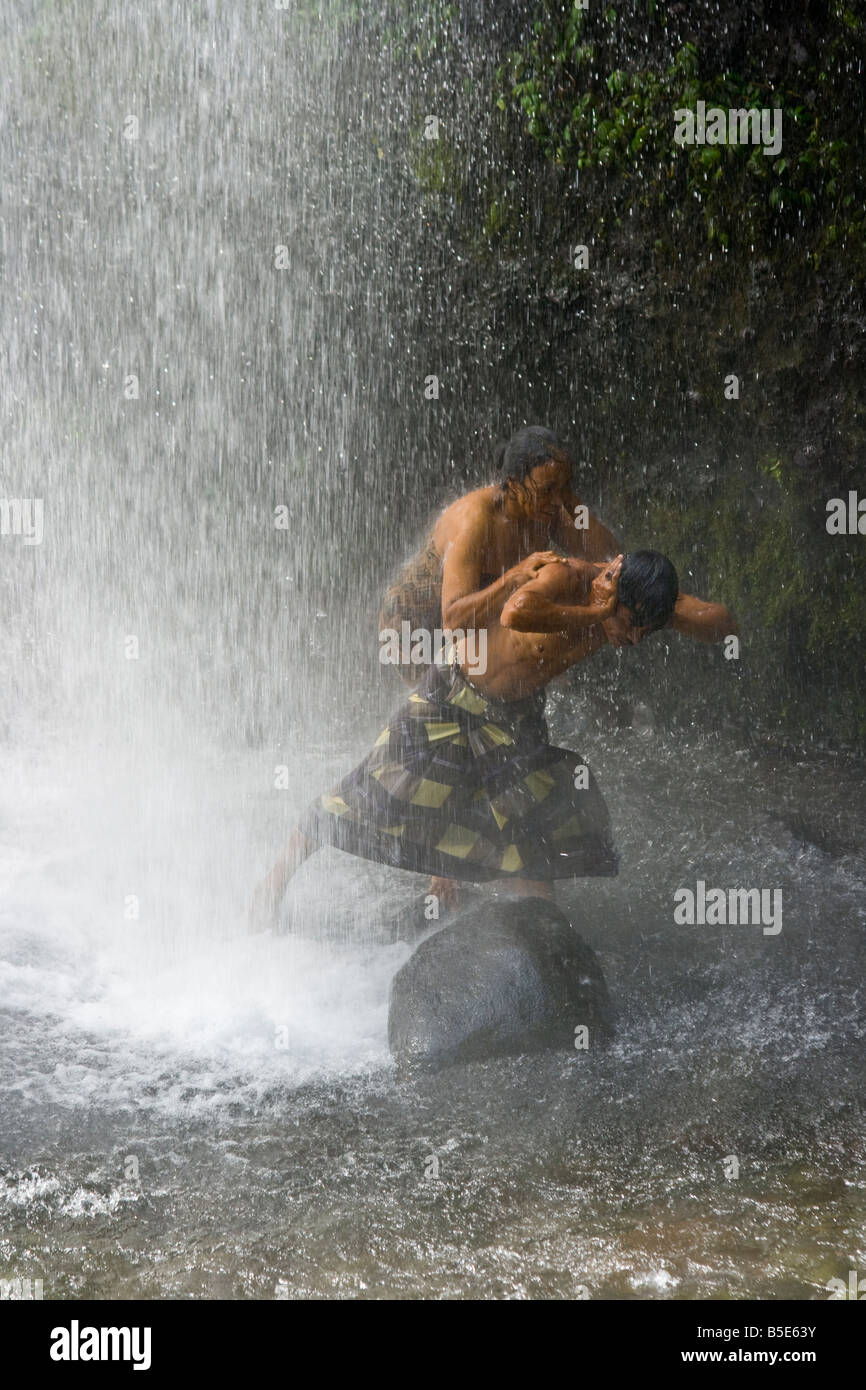 Local Man and Woman Under Sindang Gila Waterfall in Senaru on Lombok Island in Indonesia Stock Photo