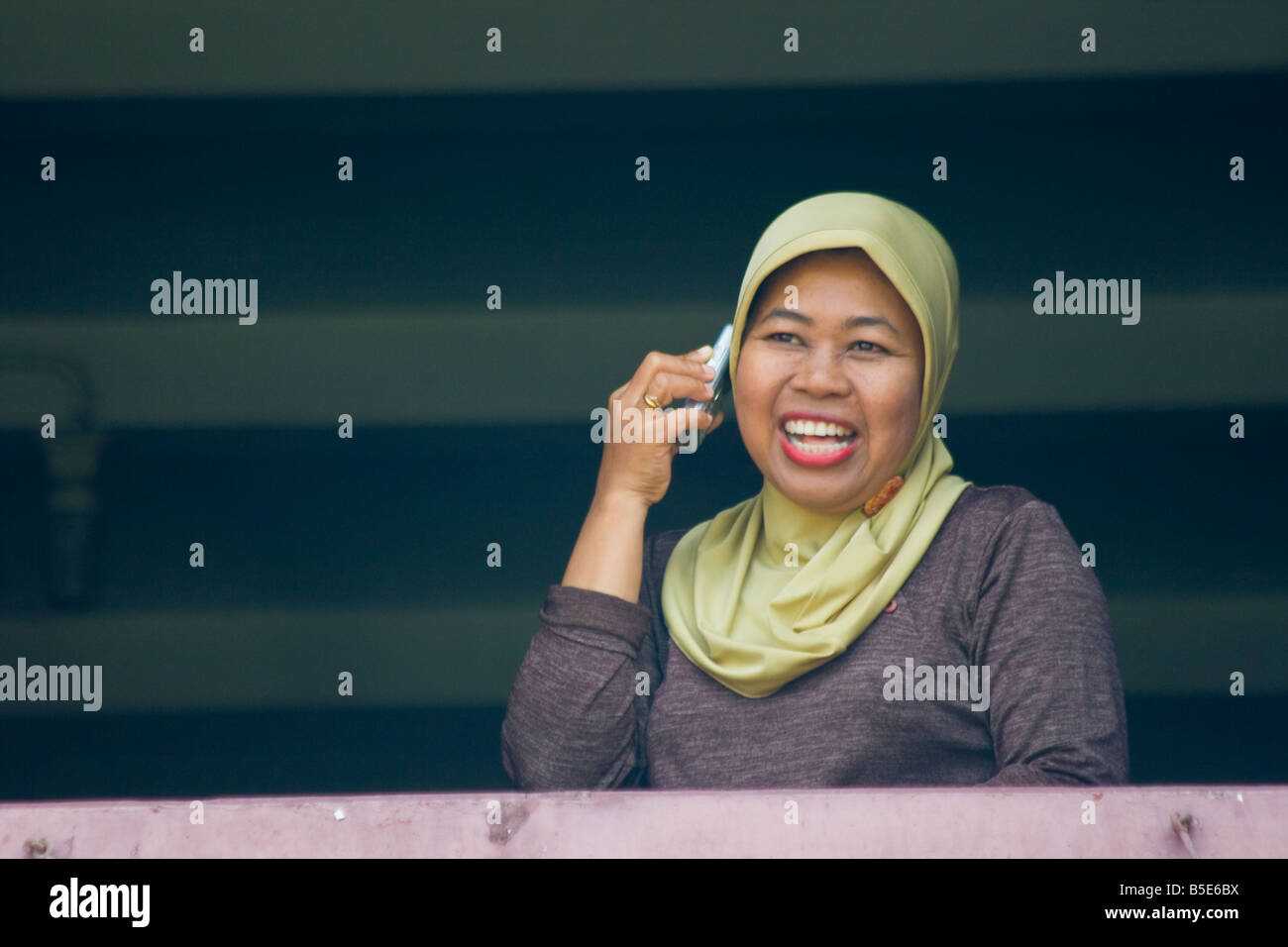 Indonesian Woman Using a Cellphone in Makassar on Sulawesi in Indonesia Stock Photo