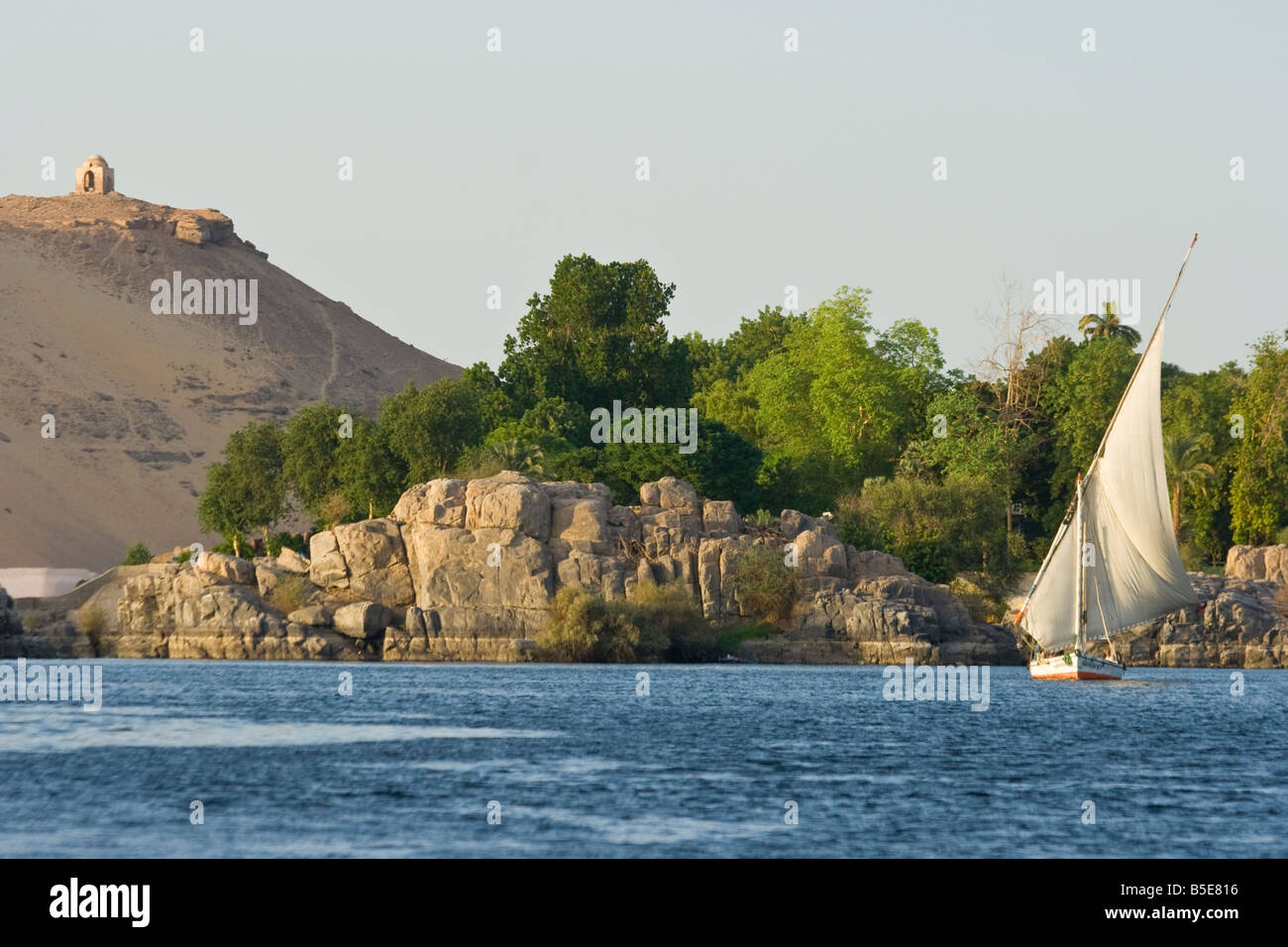 Tomb of Qubbet El Hawwa with Felucca Sailboat on the Nile River in Aswan Egypt Stock Photo