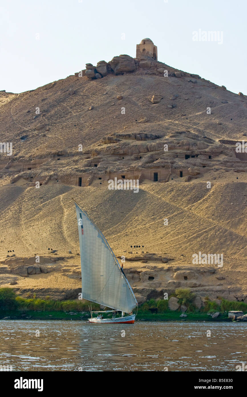 Tomb of Qubbet El Hawwa and Nobles Tombs with Felucca Sailboat on the Nile River in Aswan Egypt Stock Photo