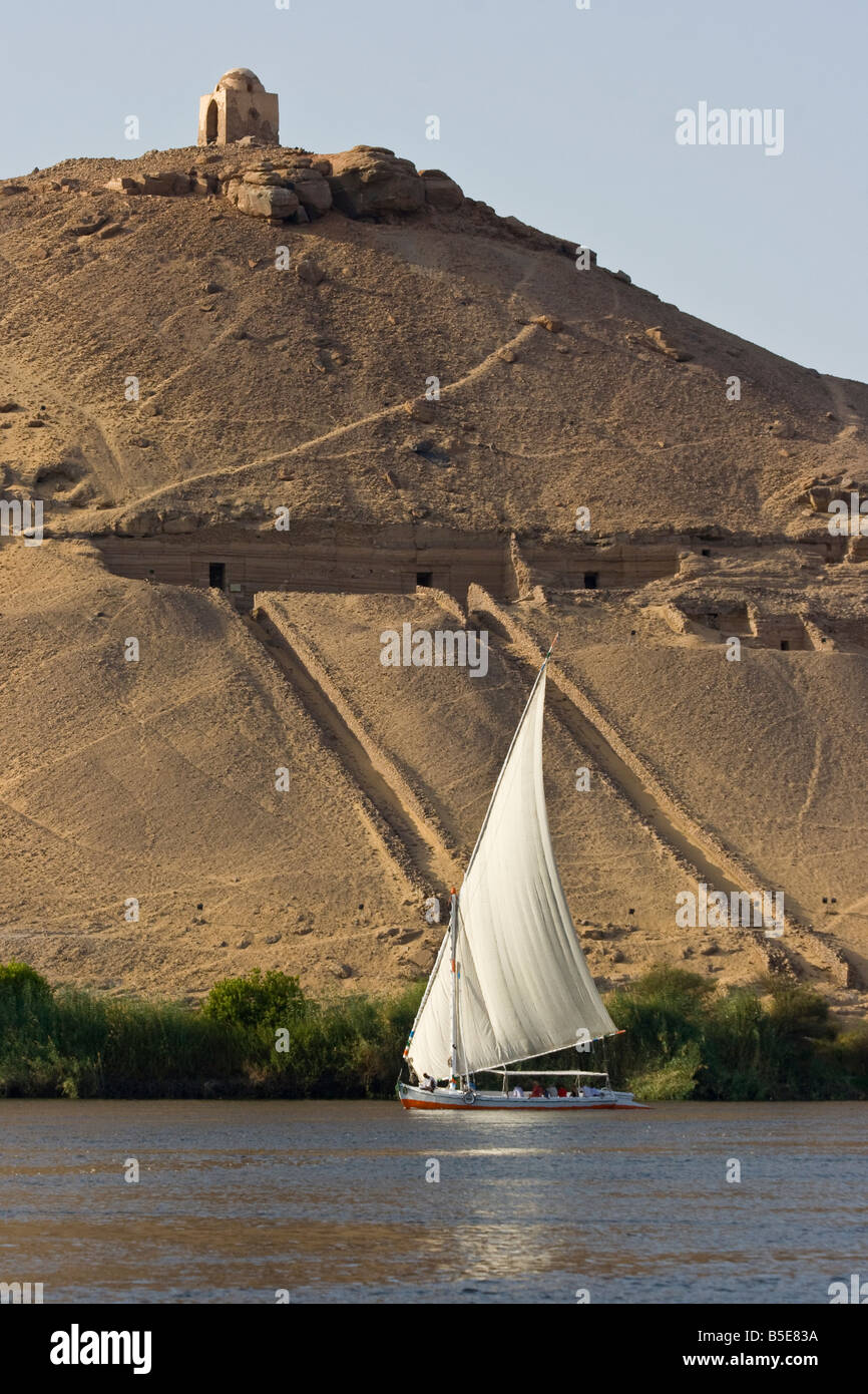 Tomb of Qubbet El Hawwa and Nobles Tombs with Felucca Sailboat on the Nile River in Aswan Egypt Stock Photo