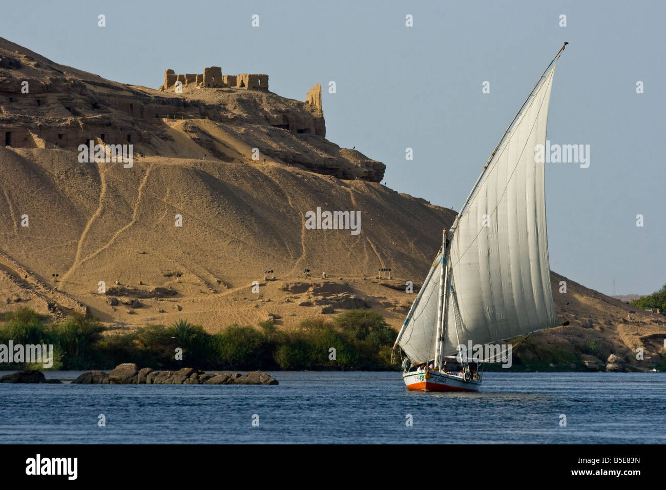 Felucca Sailboat on the Nile River in front of Gharbi Aswan or West Aswan Egypt Stock Photo