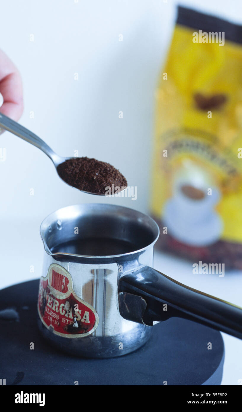 making Greek coffee in 5 steps (step: 2 put coffee in the pot with water) Crete Greece Stock Photo