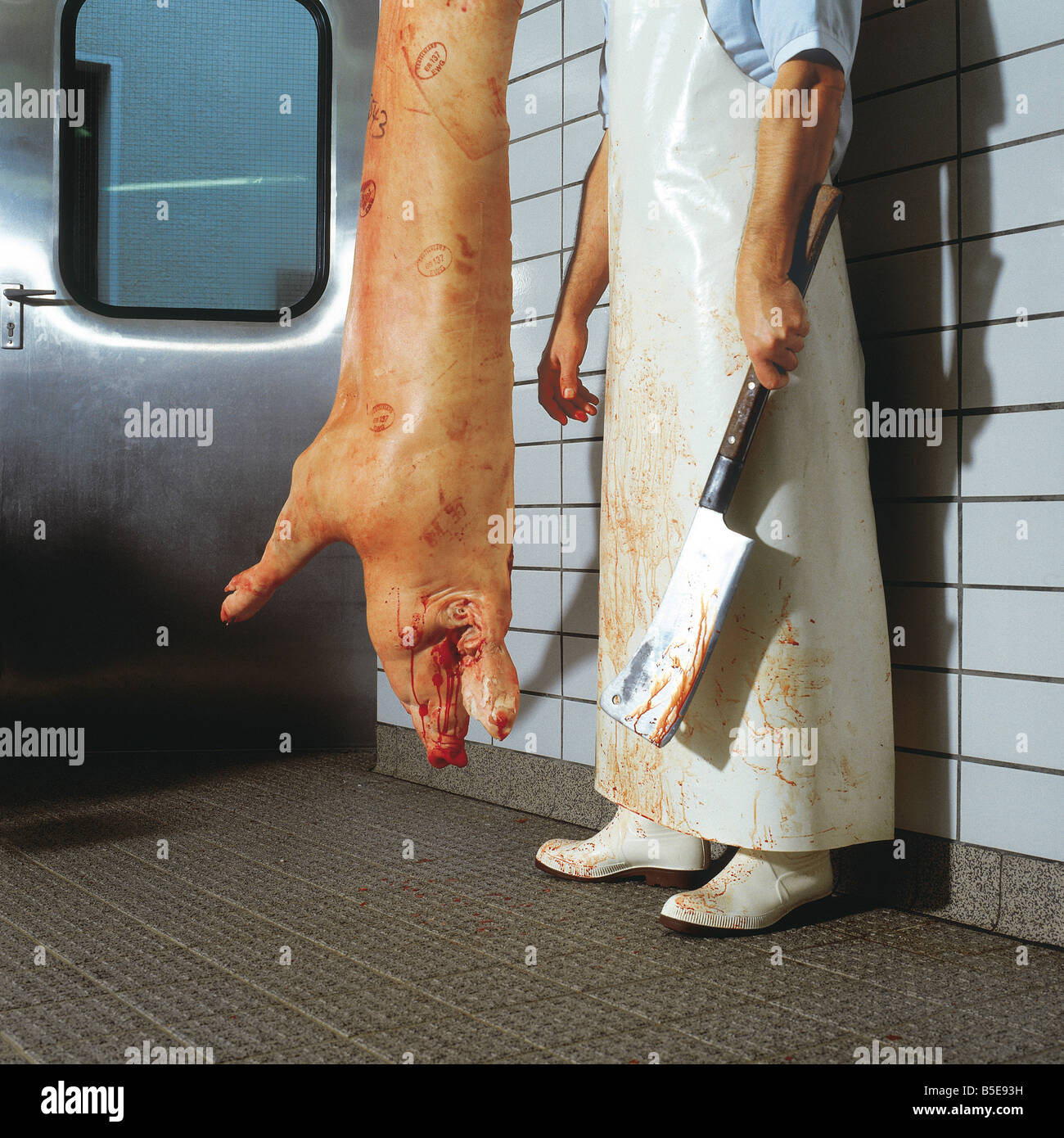 Butcher with cleaver beside a dead pig Stock Photo Alamy