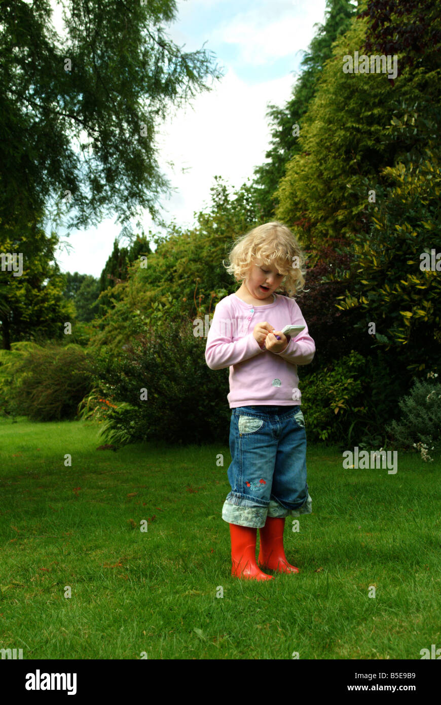 Little girl standing taking notes in red wellington boots Stock Photo ...