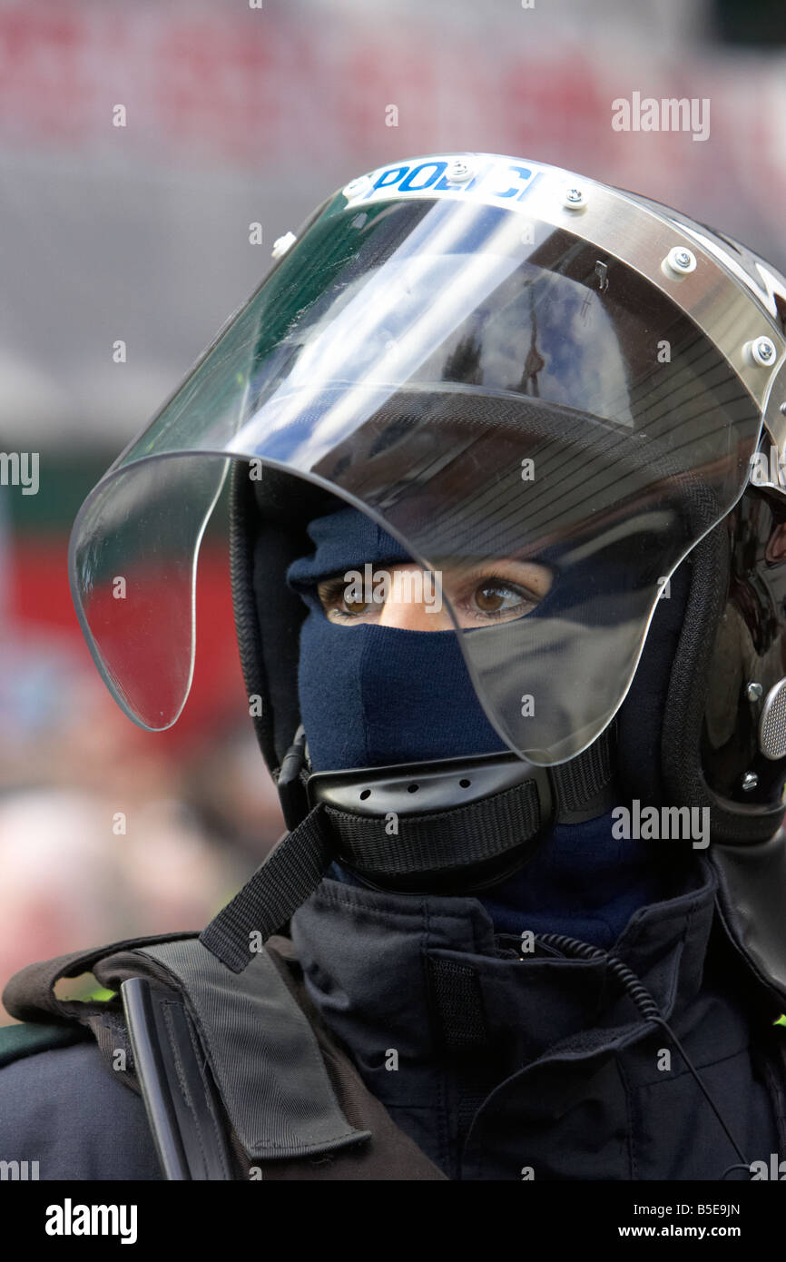 PSNI Police Service of Northern Ireland female police officer wearing riot helmet and visor watching Stock Photo