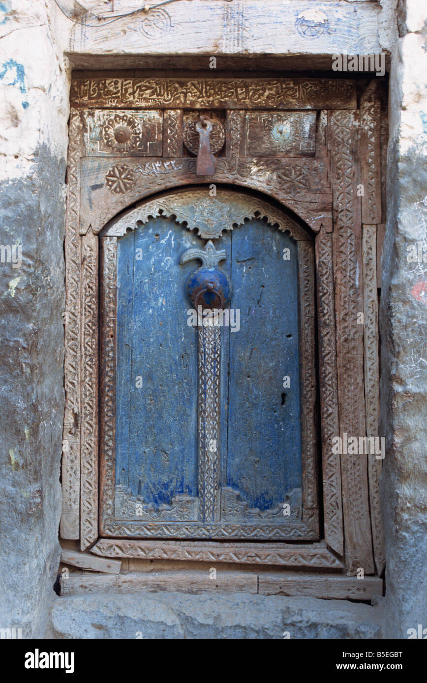 Close up of a blue door in a carved wood frame in the old city area of the Babylonian town of Sana the capital of north Yemen Stock Photo
