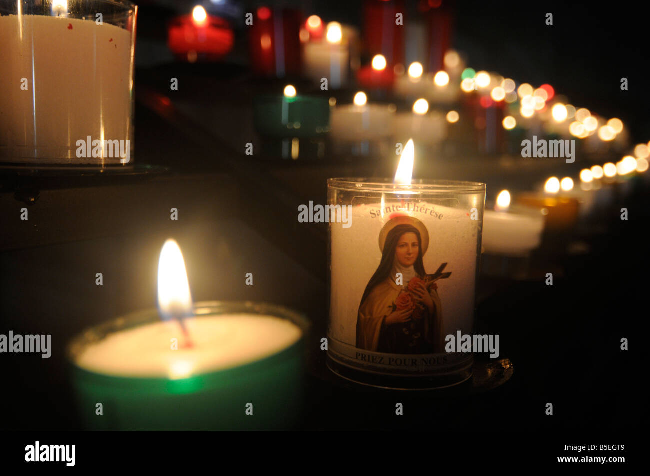 Candles with a virgin Mary icon burning inside a church in central France Stock Photo