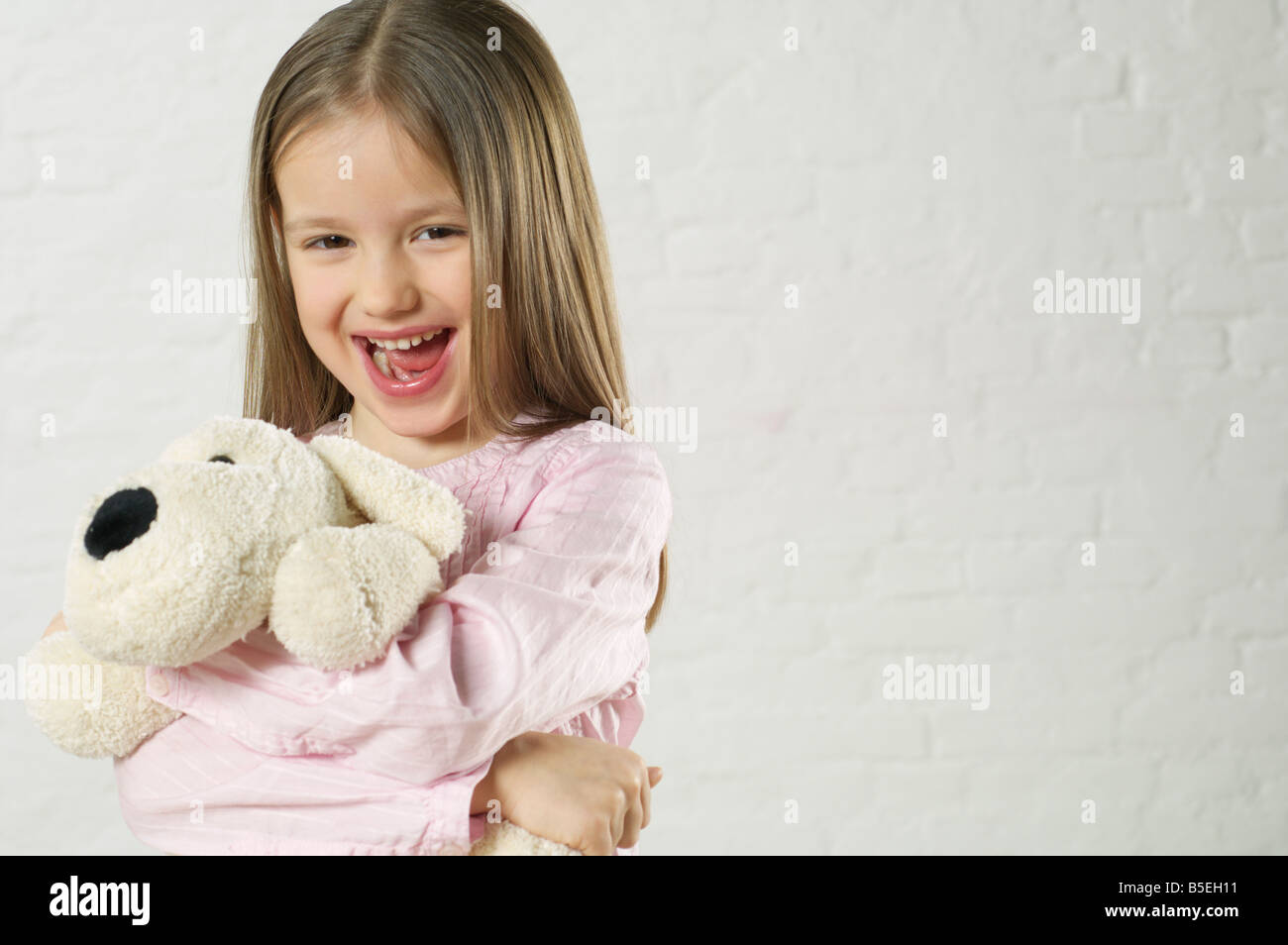 Girl holding a stuffed animal and laughing at camera Stock Photo - Alamy