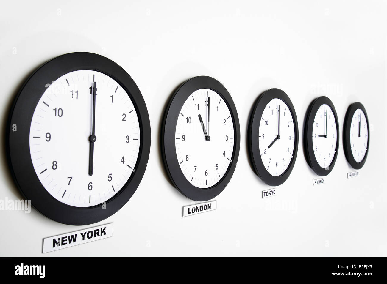Wall clocks in line displaying international time Stock Photo - Alamy