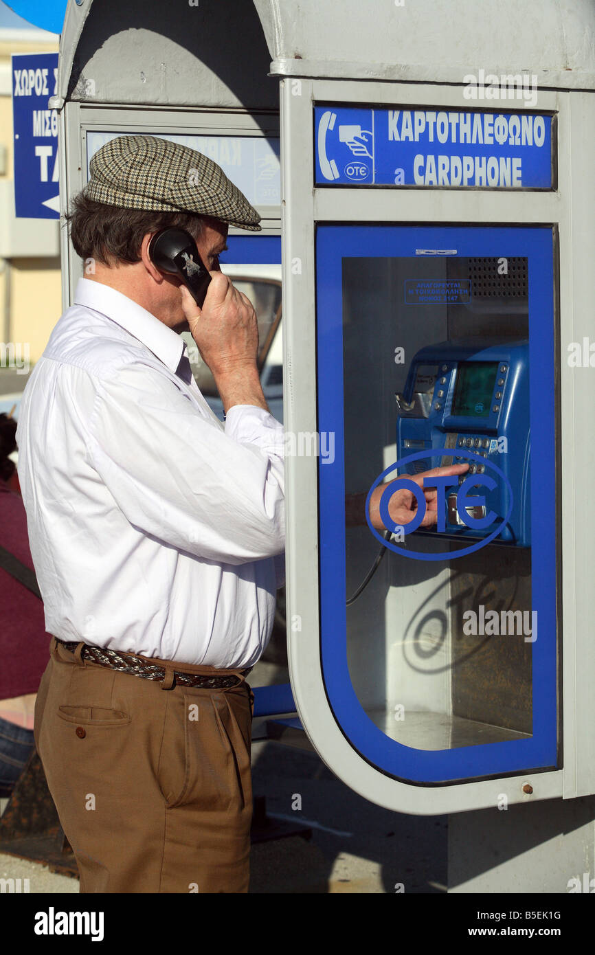 Man at a public phone booth in Rhodes, Greece Stock Photo