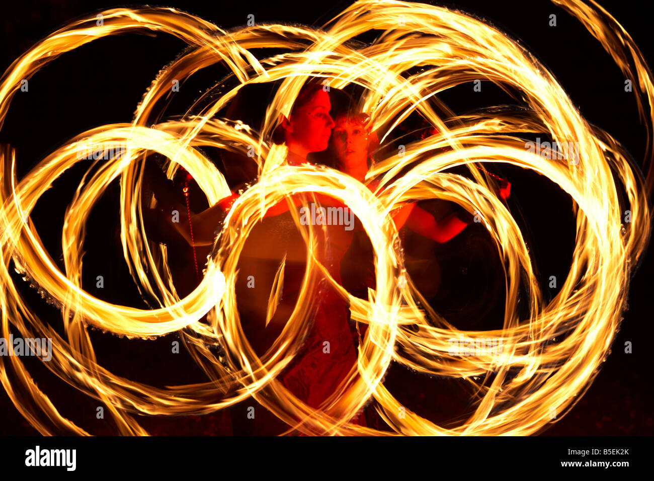 firepoise two female fire dancers dance with poi flames during