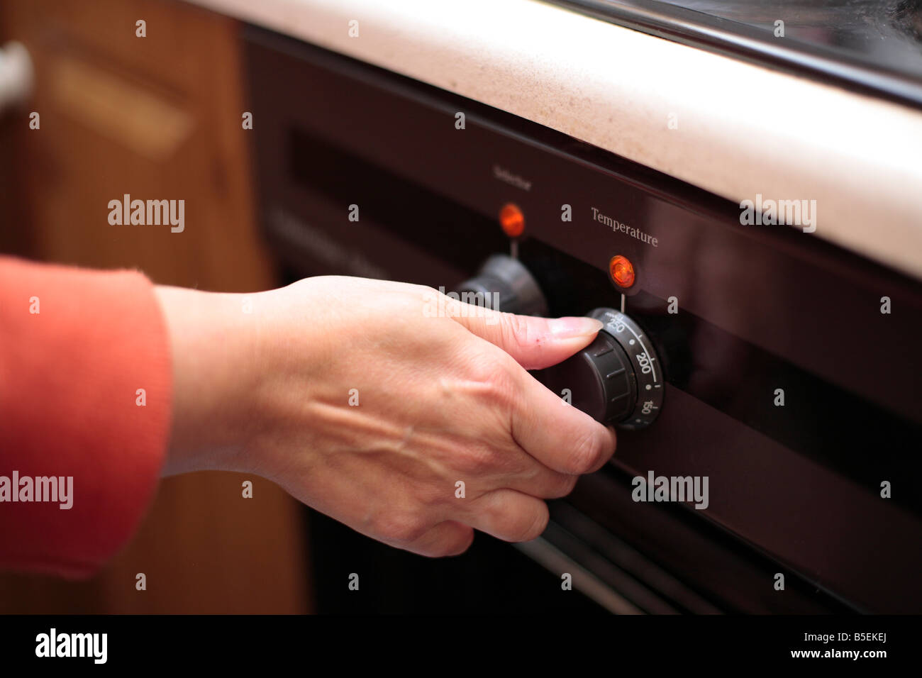 Woman setting oven temperature Stock Photo Alamy