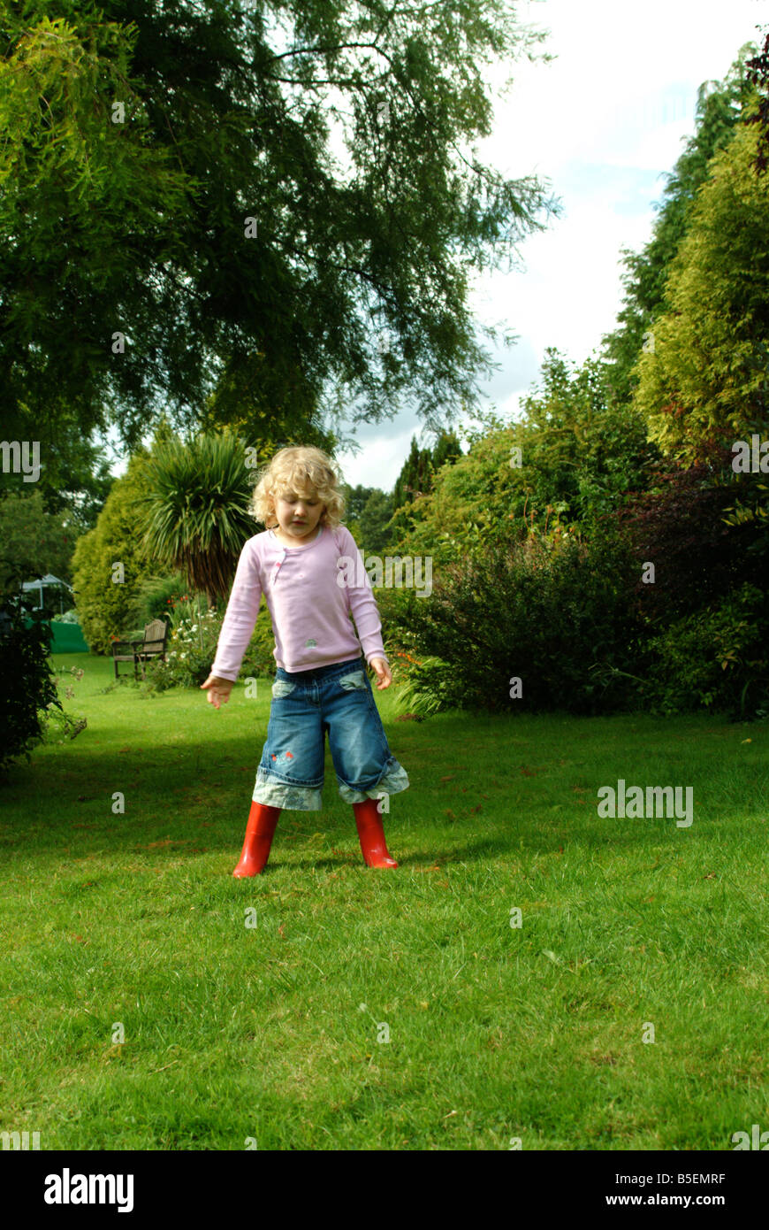 Little girl jumping in the air in red wellington boots Stock Photo - Alamy