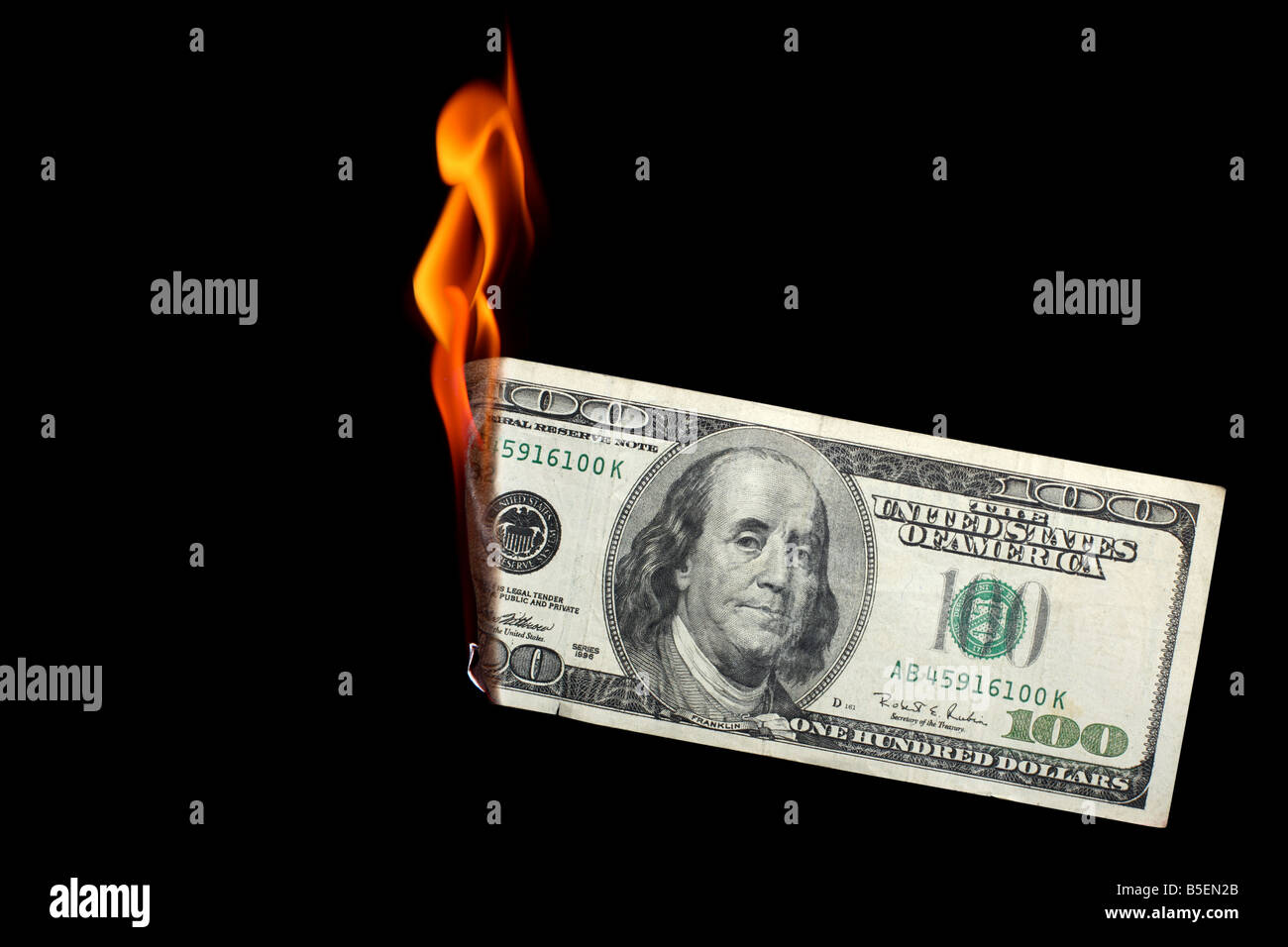 One hundred dollar bill burning on black background Stock Photo