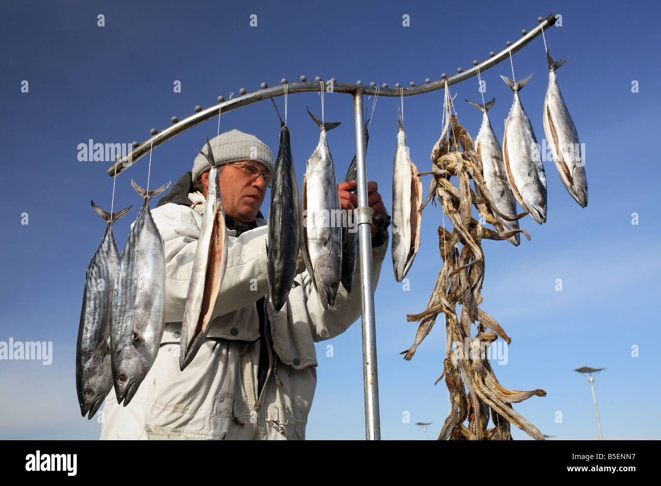 A fisherman hanging out fish to dry Stock Photo