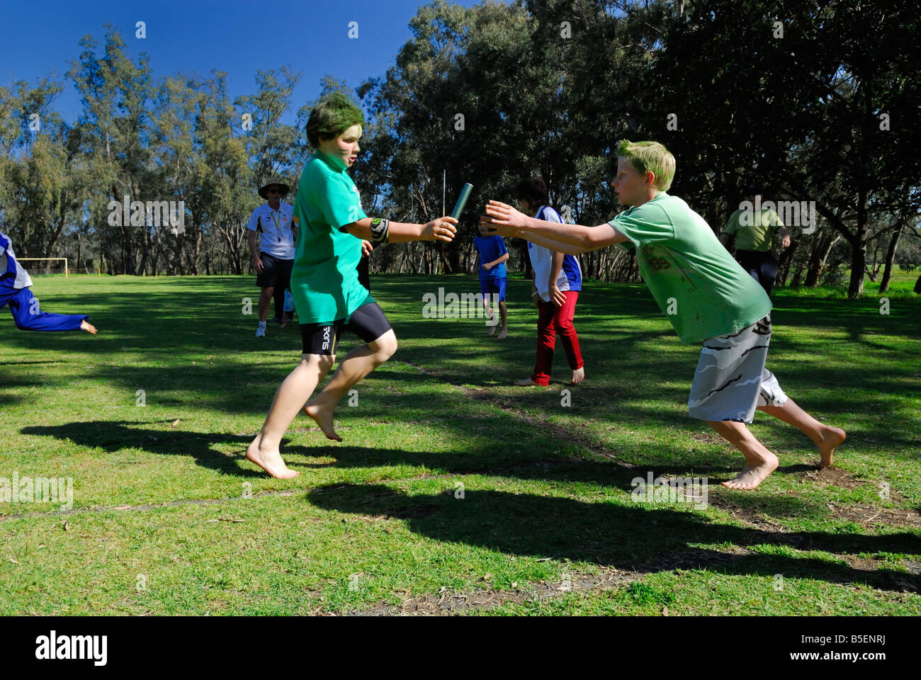 Handover of baton in relay race. Primary school sports day in Australia