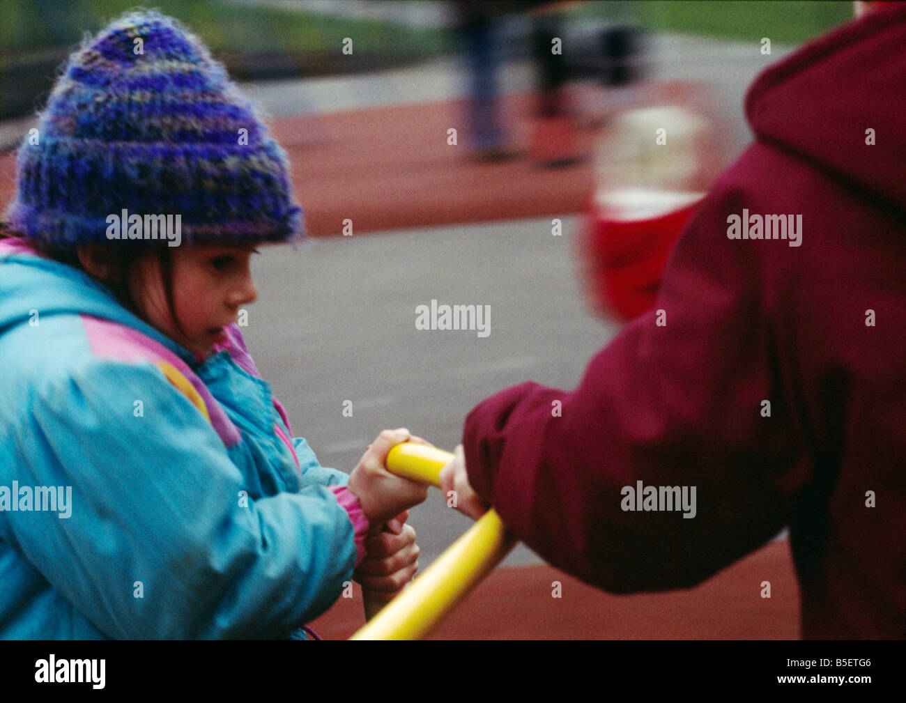 Primary school children play on roundabout Stock Photo