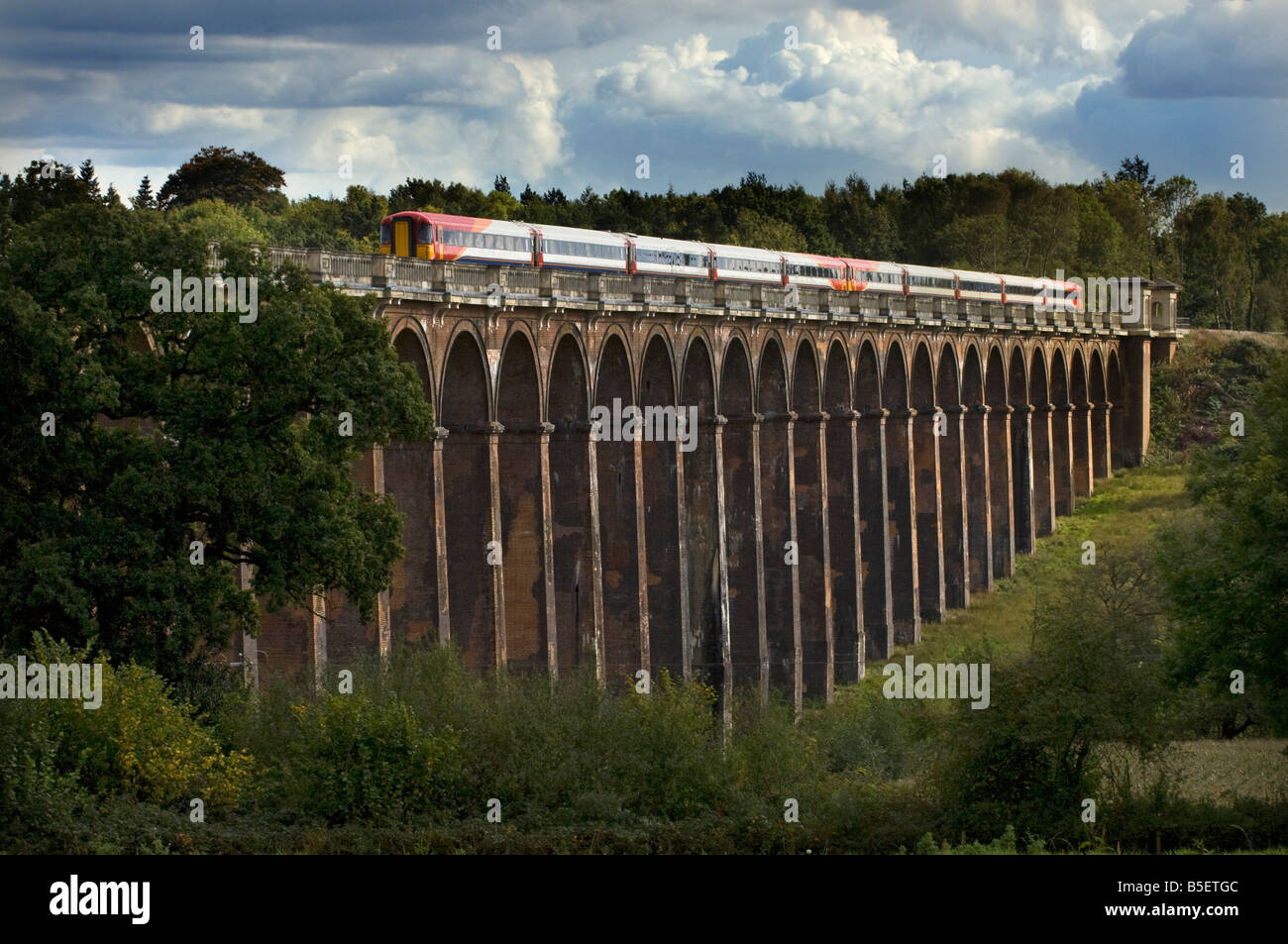 A South West Trains commuter express train crosses the Ouse Valley Viaduct at Balcombe near Haywards Heath, Sussex Stock Photo