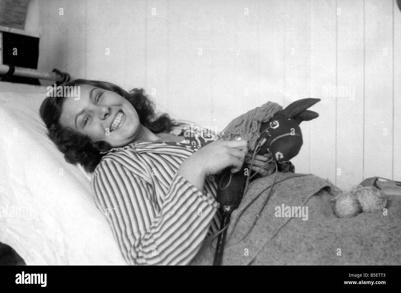 Teenager Susi Kstona who was brought to the Belsen concentration camp from Poland by the Nazis in 1943, now recovering in the Glyn Hughes hospital in Luneberg following the liberation of the camp by Allied forces. ;She is holding a toy horse that she made from old German uniforms and bits of wood;November 1945 Stock Photo