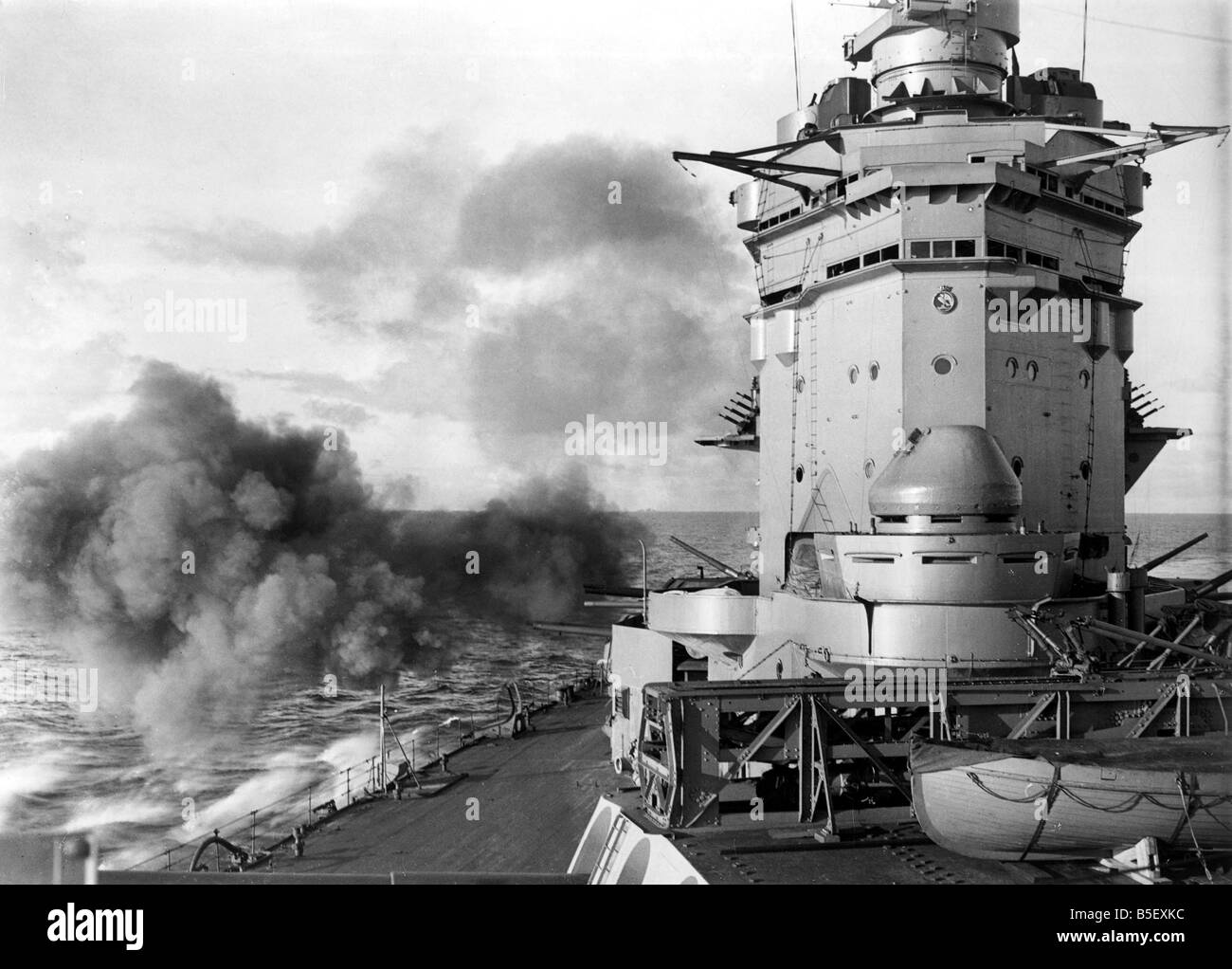 British battleship HMS Rodney of the Royal Navy firing her secondary armament of six inch guns during exercises at sea in the Second World War;December 1940; Stock Photo