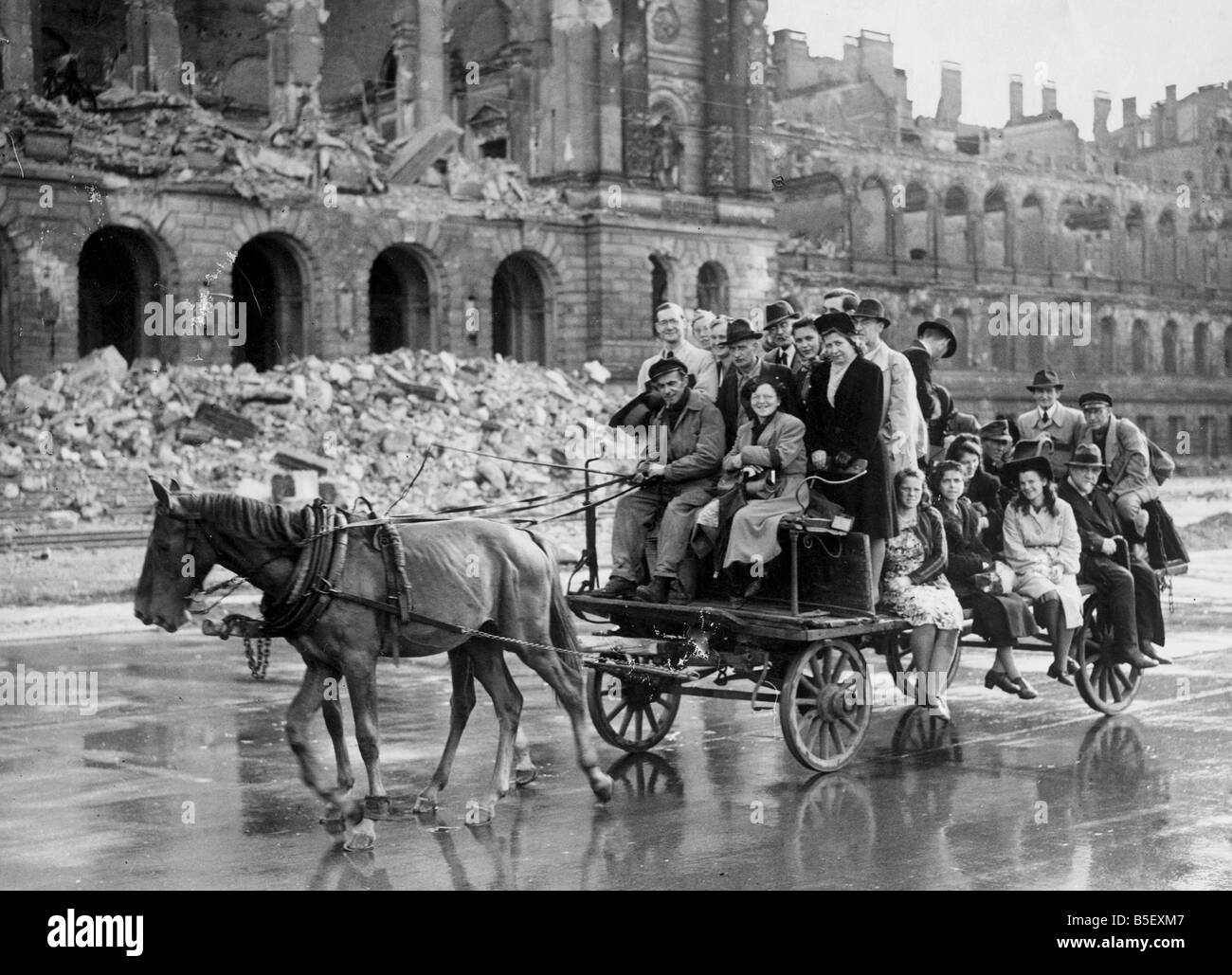 Britsh army units arrive in the German capital city of Berlin to take up their occupation positions in the Allied Zone. Local Berliners make their way home in a horse drawn cart with the ruins of the Engineering college behind them;July 1945 Stock Photo