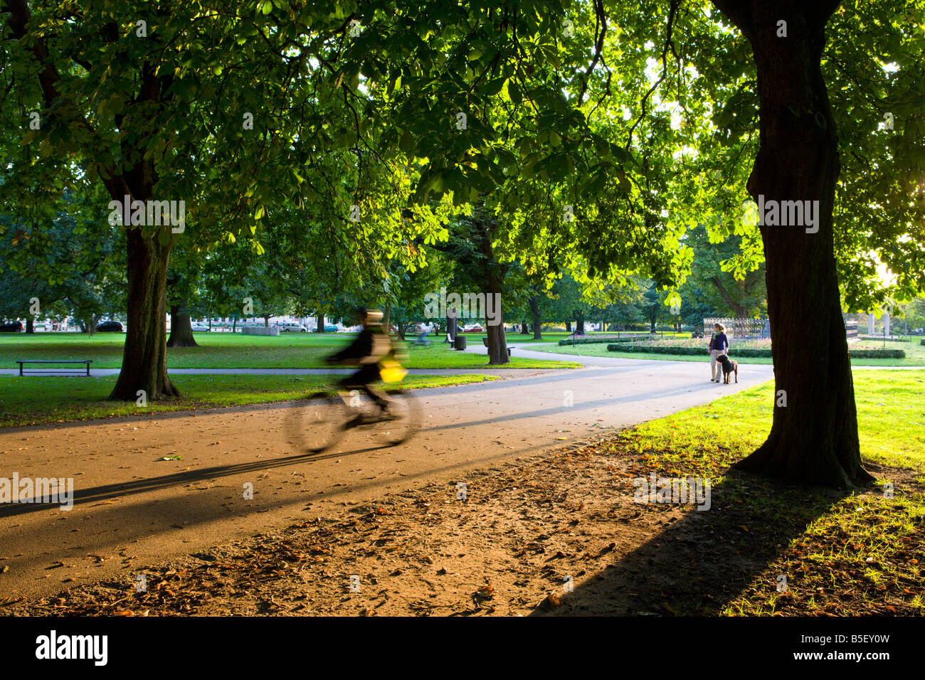 Cyclist and dog walker in Watts Park Southampton City Centre Hampshire England Stock Photo