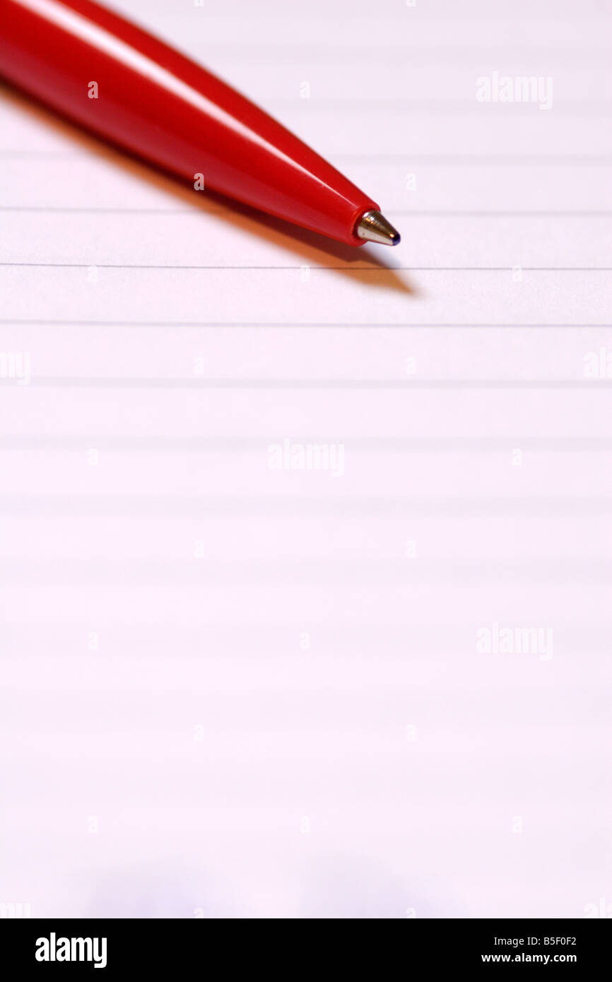 Red biro pen on lined paper close up Stock Photo Alamy