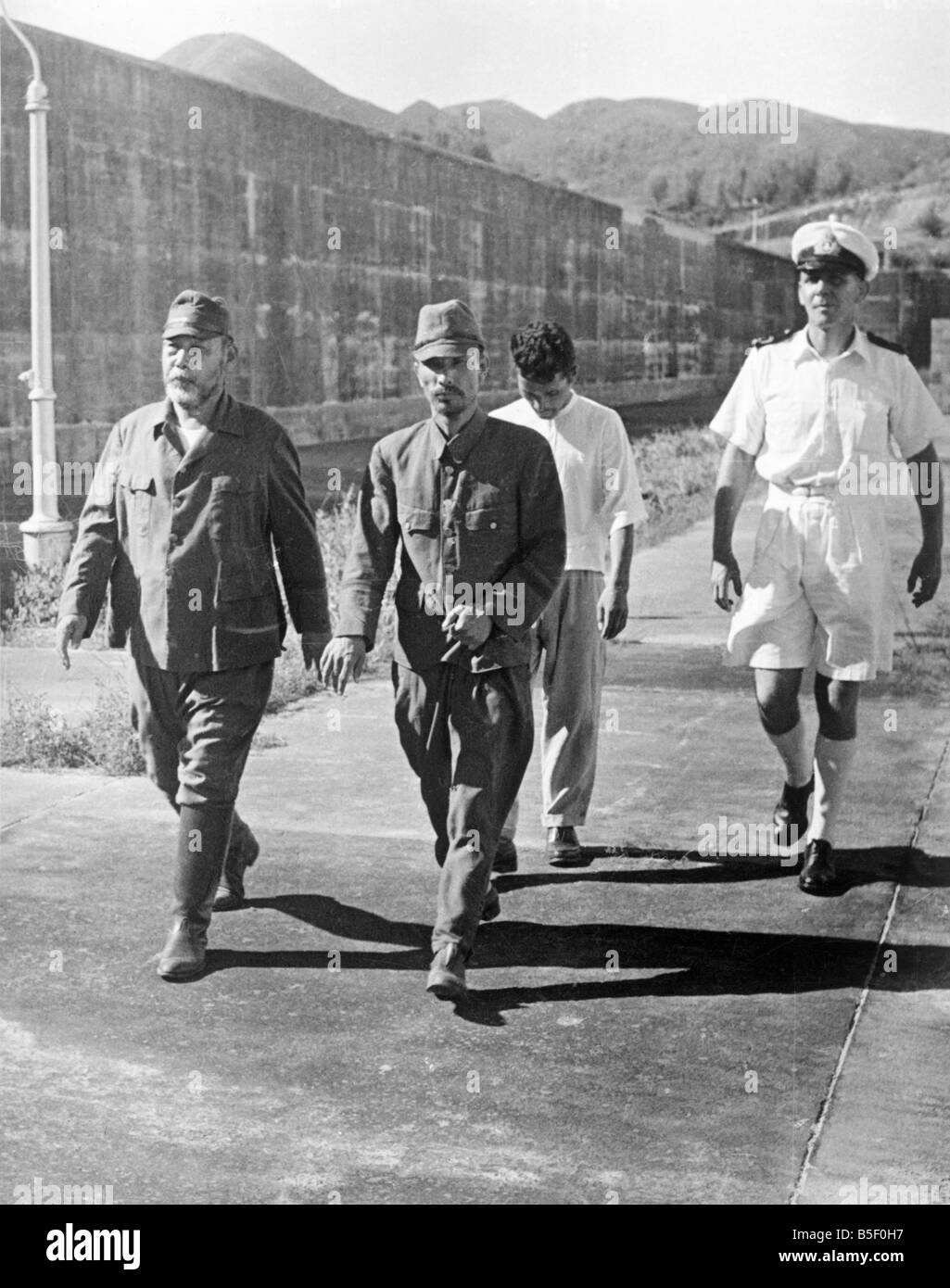 Japanese POWs war criminals and British collaborators jailed at Hong Kong. Sub-Ltn. P.J Poole of Newport is seen walking in the Stock Photo