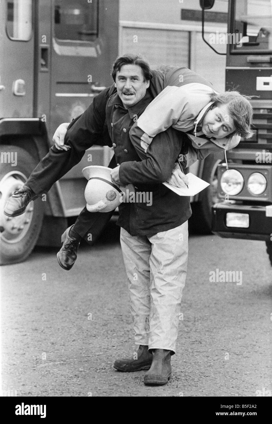 Pouring cold water on the report s claims that firemen are unfit is leading fireman John Kerr who shows there e nothing wrong with his fitness as he gives Chronicle reporter Bill Lothian a fireman s lift Stock Photo