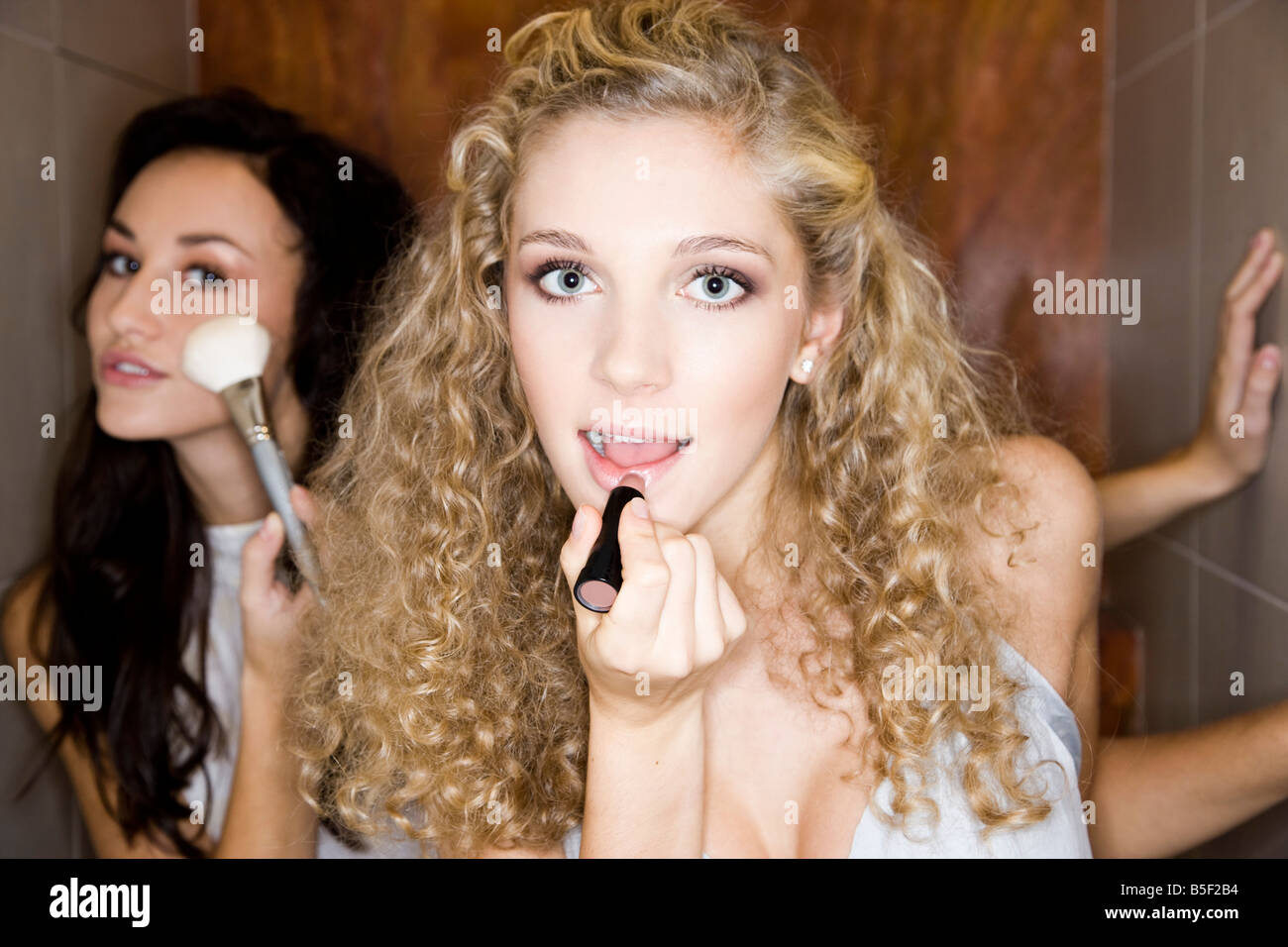 girls doing make-up in bathroom Stock Photo