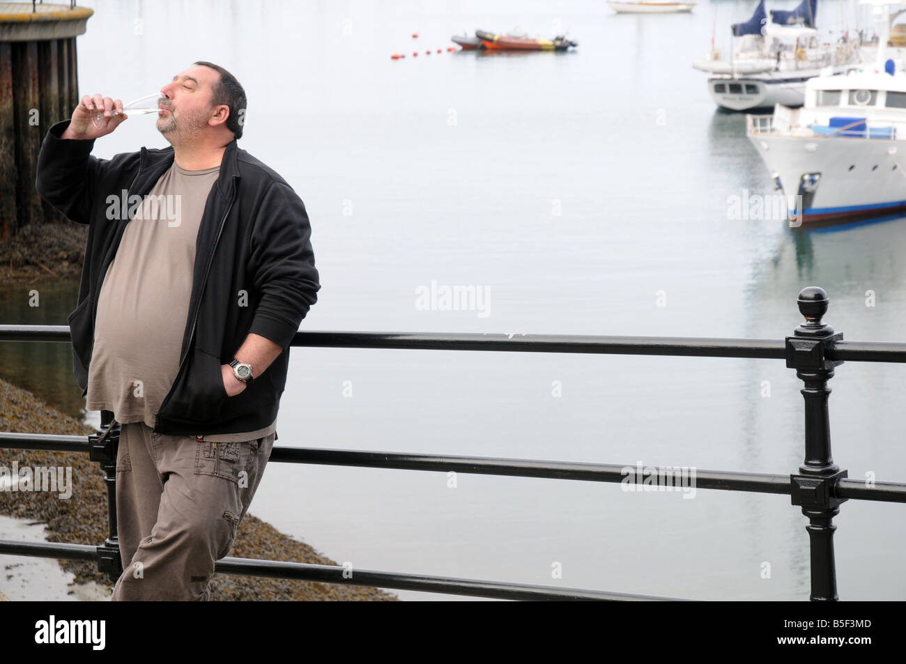 An untidy man drinks champagne at the Falmouth Oyster Festival, UK Stock Photo