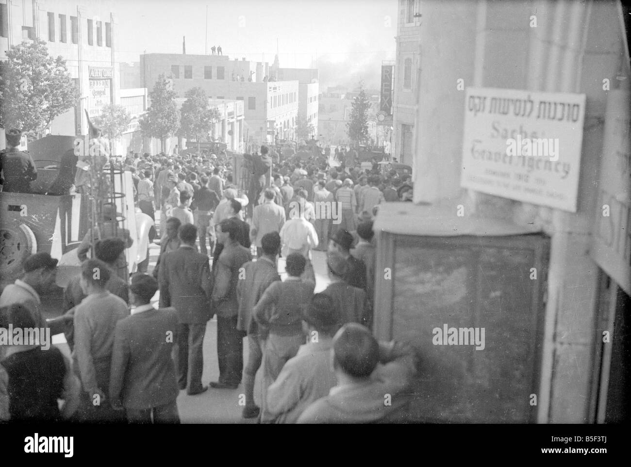 On February 22, 1948, as the conflict over the coming partition of Palestine grew, three car bombs arranged by Arab irregulars exploded on Ben Yehuda Street killing 52 Jewish civilians and leaving 123 injured. Two British deserters were involved in the attack, having been promised pay by Abed al-Kader al-Husseini, who was the commander of the Holy War Army forces in the area. British involvement was claimed because the alleged armored trucks with police insignia had escorted the truck bombs into the area. Our Picture Shows: Crowds mill about close to the scene of the first explosion Stock Photo