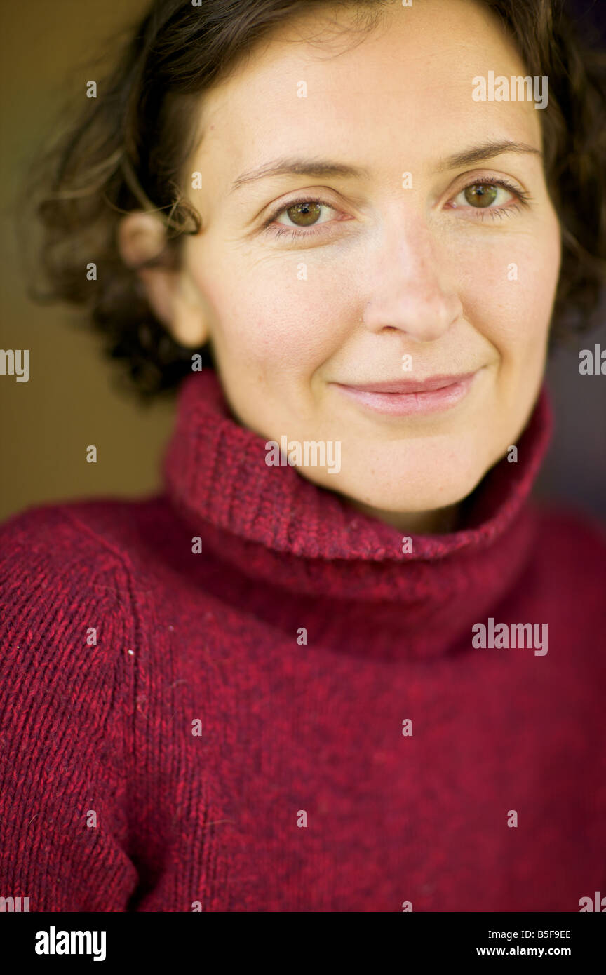 Hazel eyed woman smiles enigmatically at the viewer. Smile's the wrong word, more like a mona lisa smirk. Stock Photo