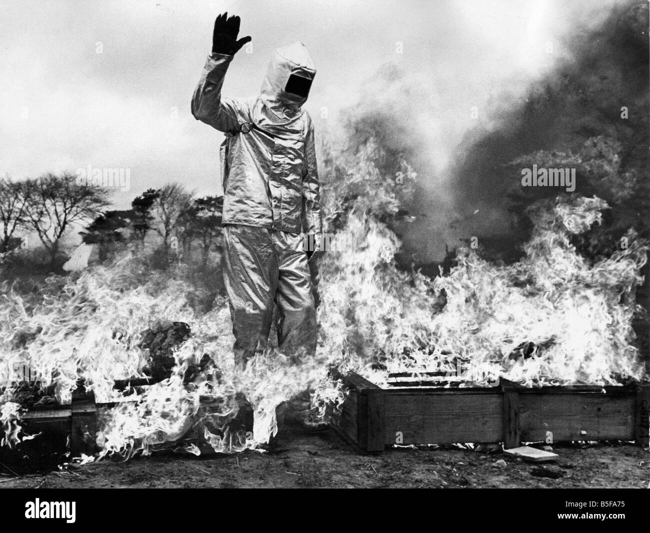 Firefighter Dave Katz walks throught a tunnel of fire to demonstate the fireproof suit Stock Photo