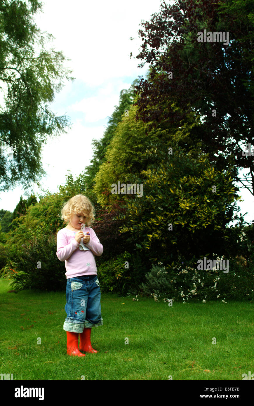 Little girl standing taking notes in red wellington boots Stock Photo ...